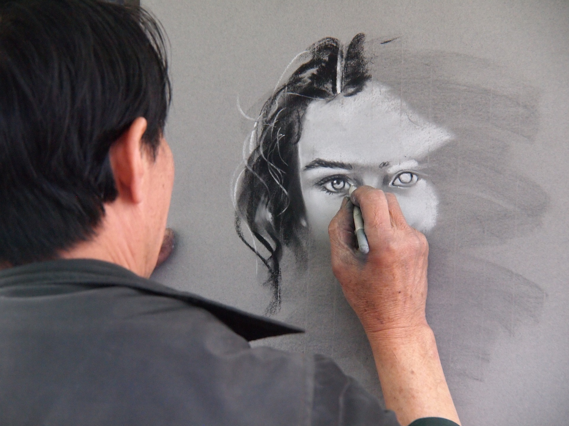 Artist draws sketch of woman on wall