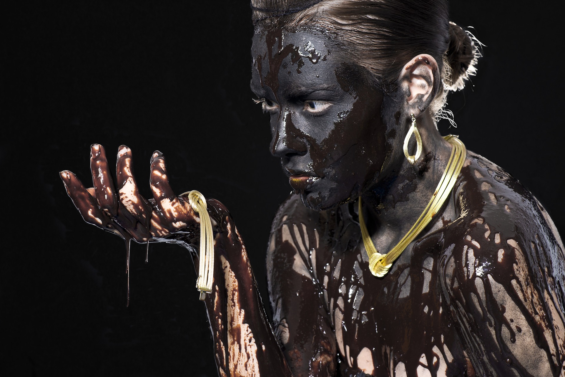 Woman full with black chocolate and gold jewellery