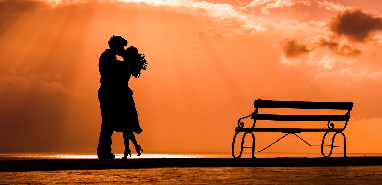 couple-romance-love-bench-sunset-orange Romance loving couple in orange sunset with bench