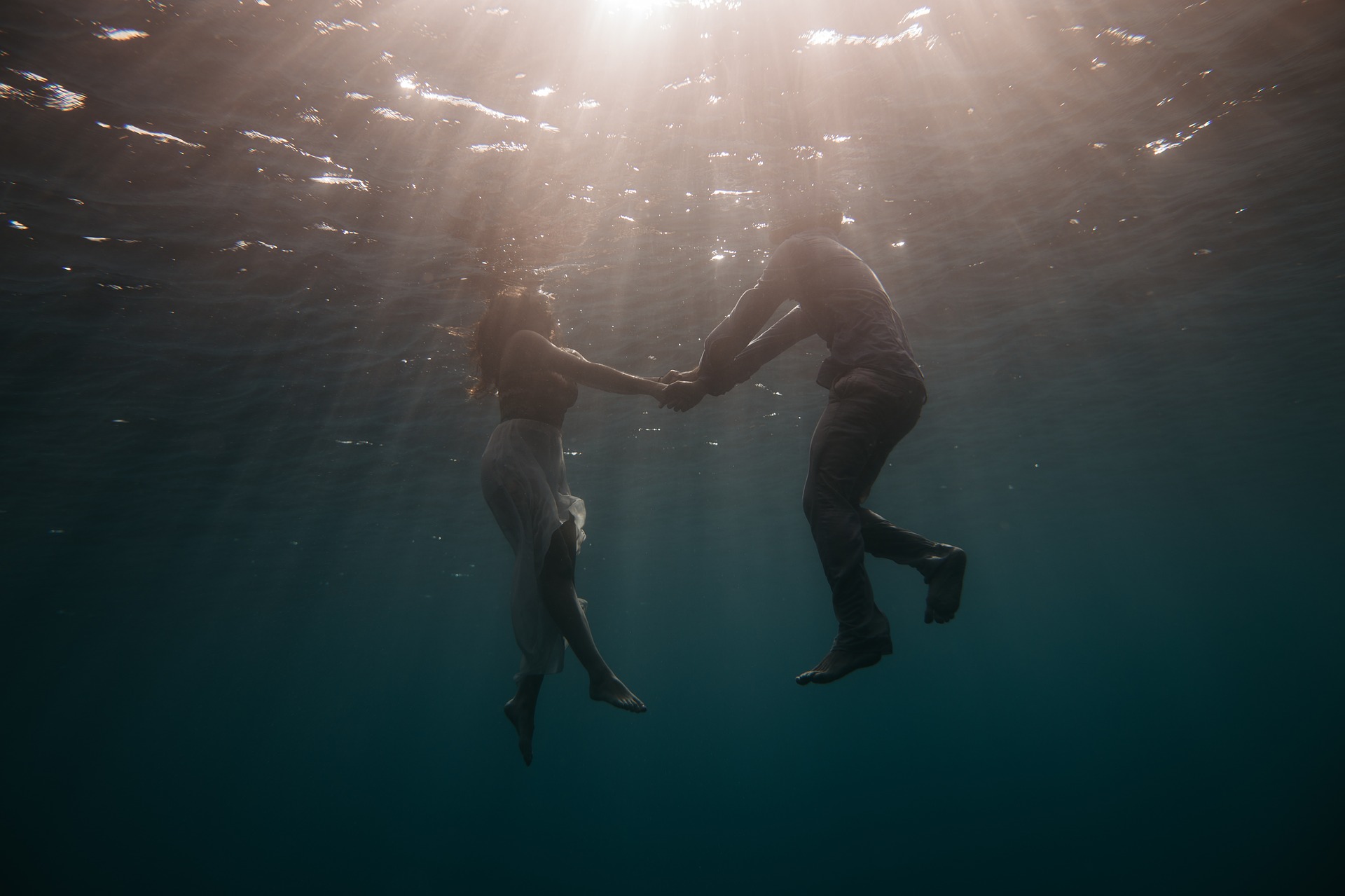 Couple swimming underwater in sea, lake
