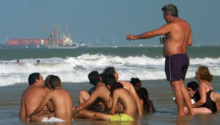 Familiy at the beach sitting in the sea.