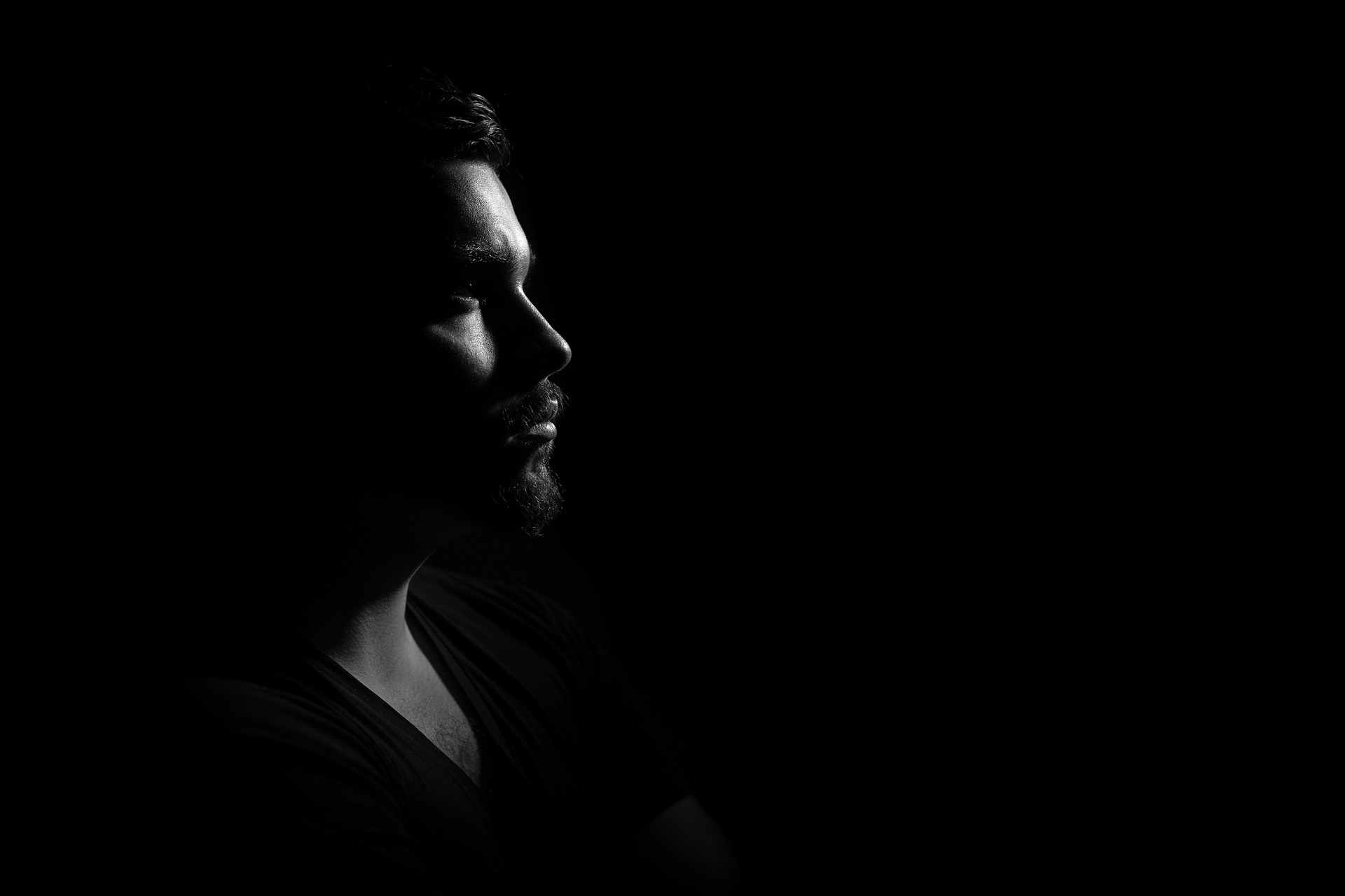 Gloomy profile foto of man - black background