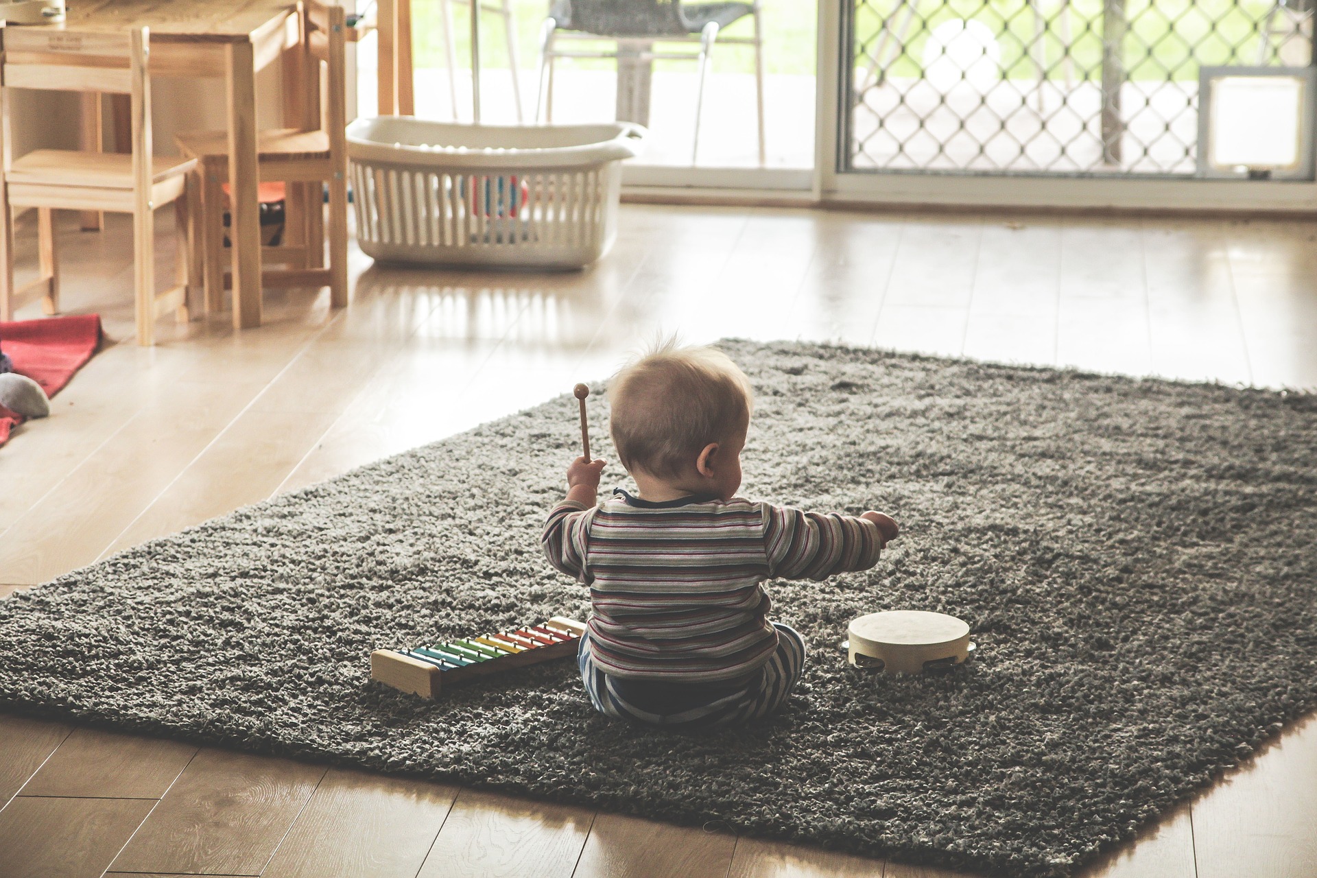 Baby playing xylophone music on carpet