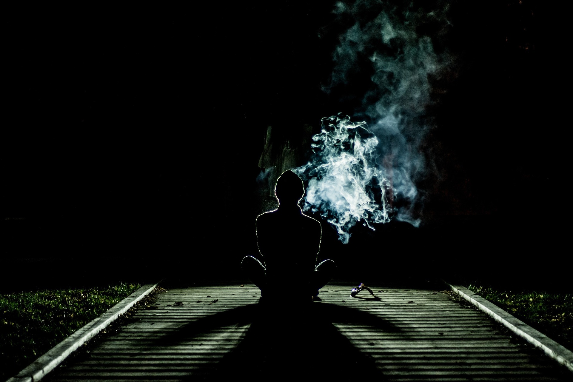 Human meditating and smoking, possibly Marijuana