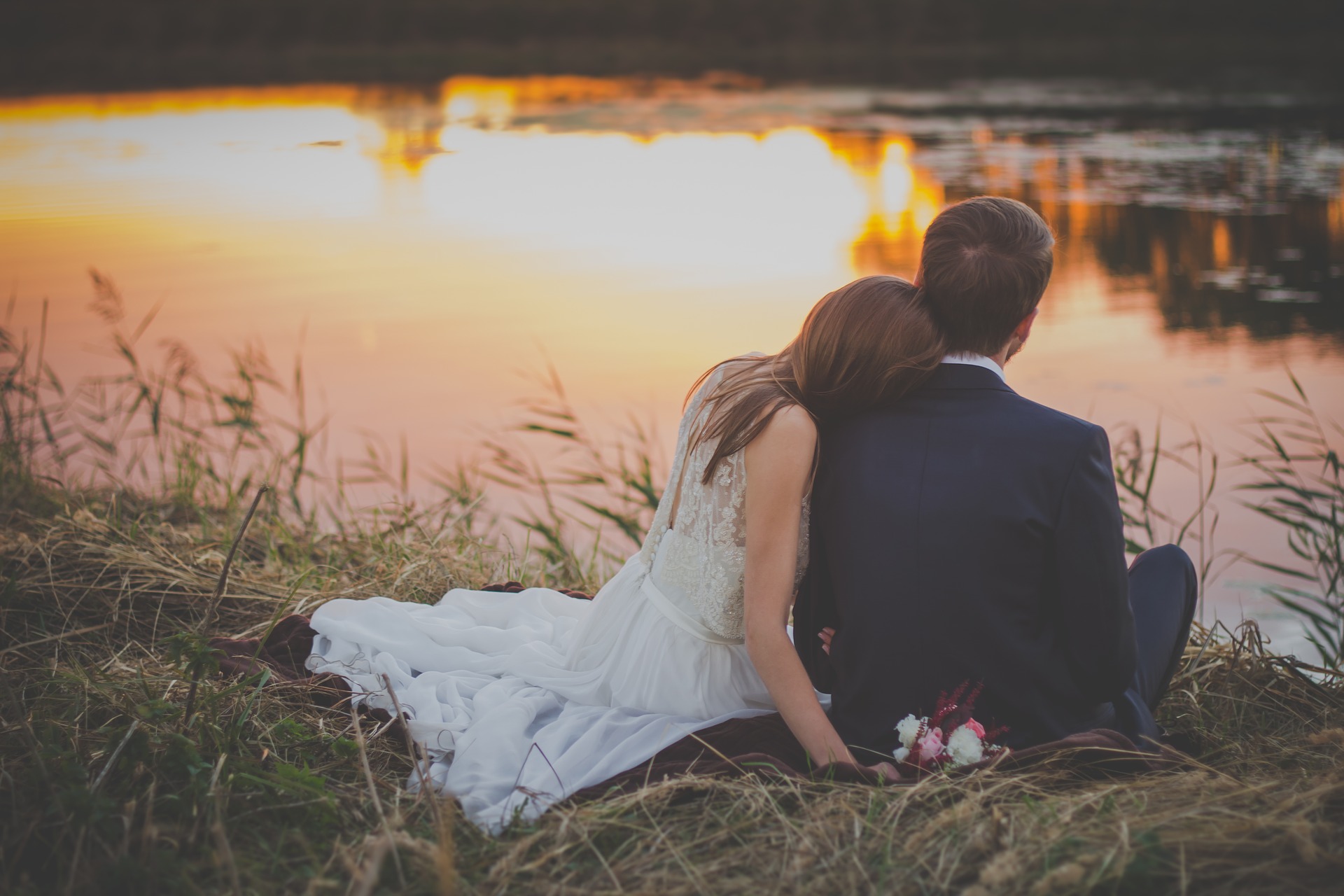 Wedding: Bride and groom at a lake reflecting sun-light