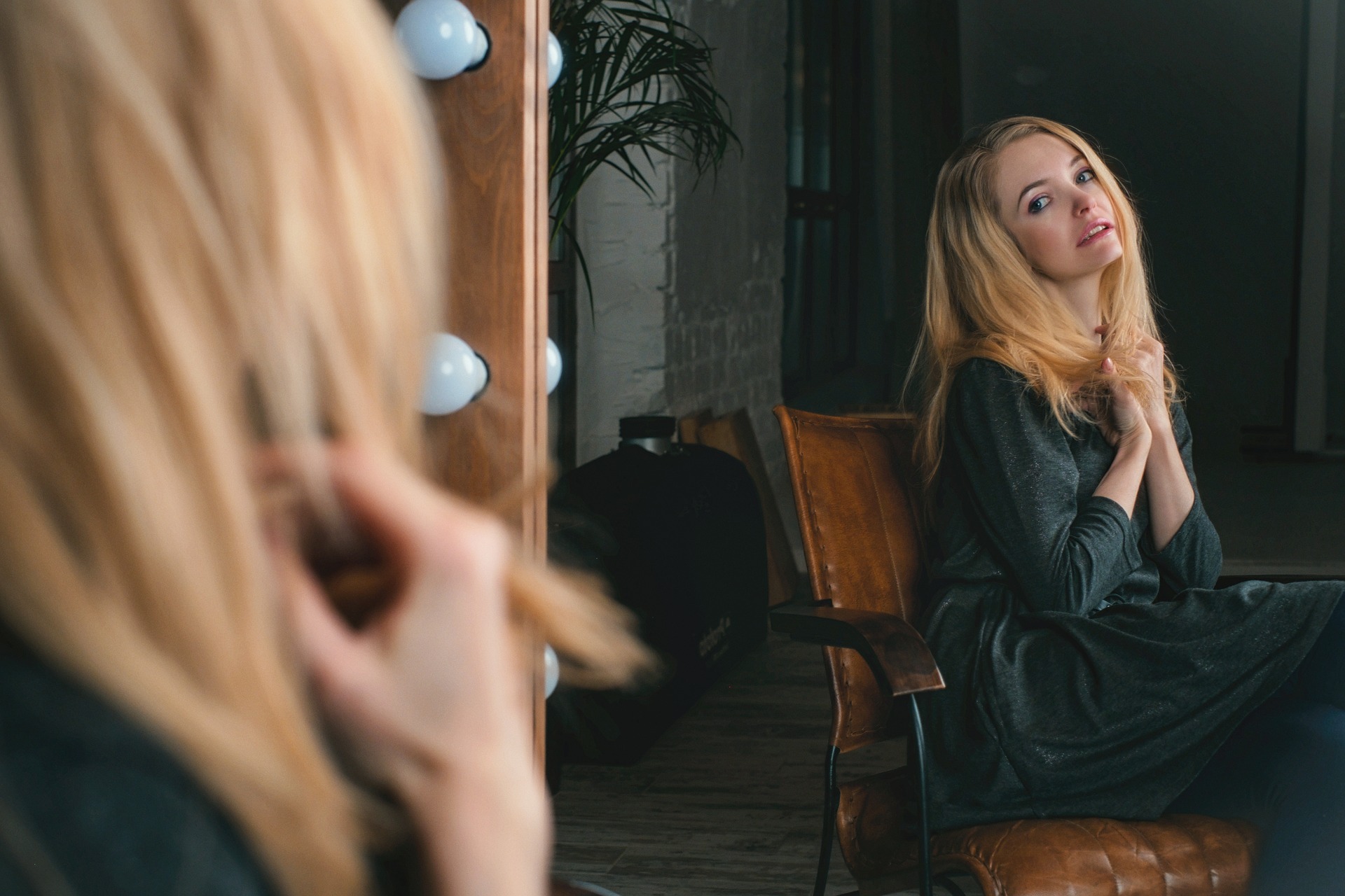 Blonde woman watching herself lovingly in the mirror